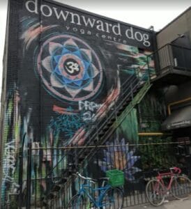 Exterior of Downward Dog Yoga Centre in Toronto s Ontario with a beautiful graffiti on the side of building entrance.